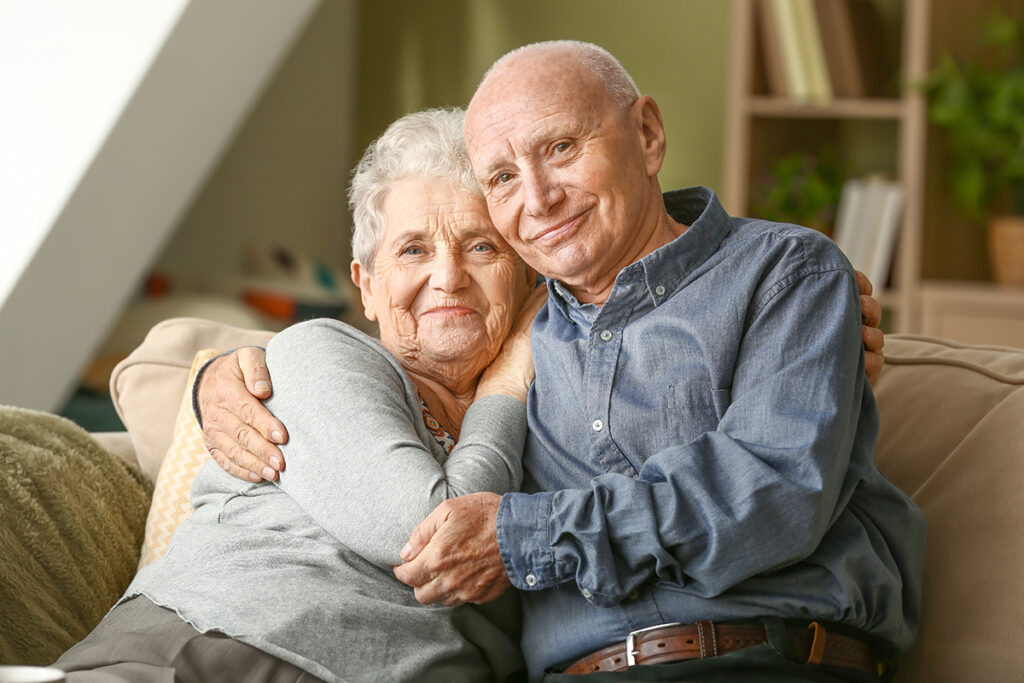 two people sitting with arms around each other in assisted living for couples
