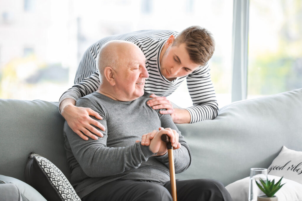 Man checking in on senior sitting on couch