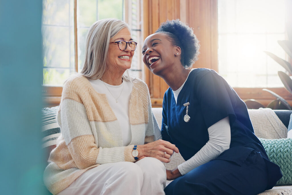 caregiver and resident laughing while discussing assisted living vs in home care
