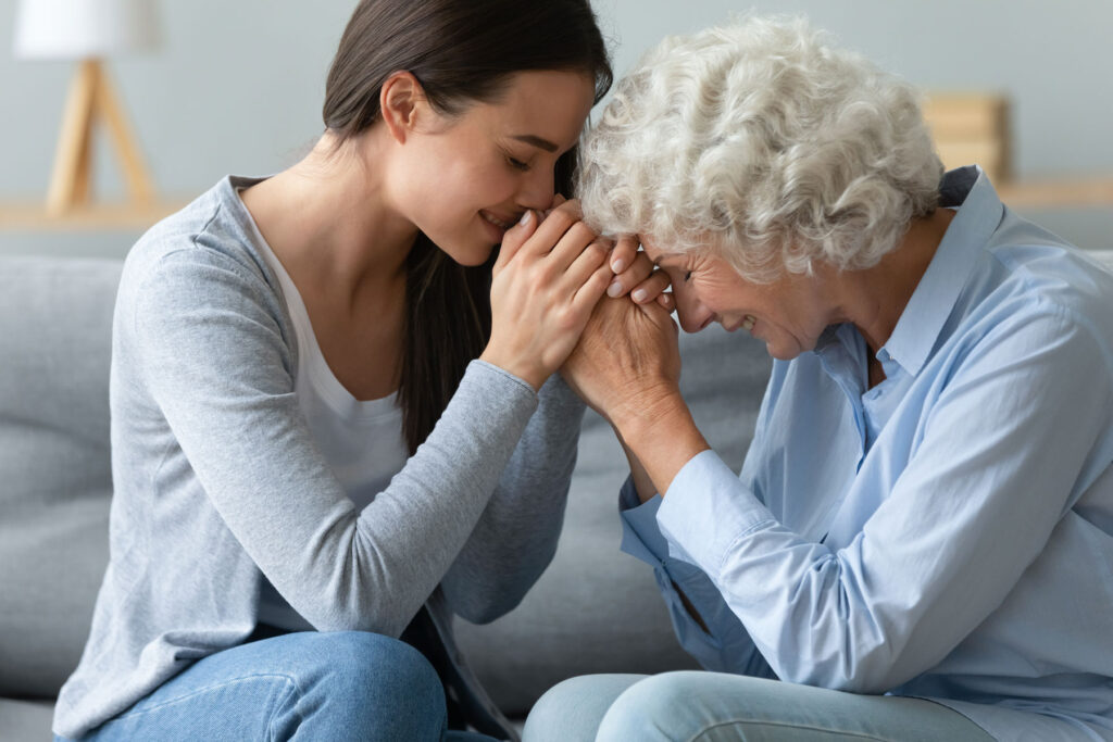person joining hands with older woman while discussing fear of change
