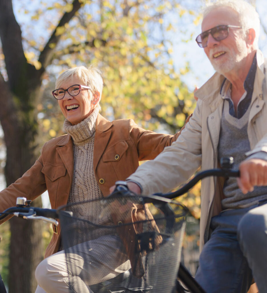 a senior couple enjoys a sunny bike ride together
