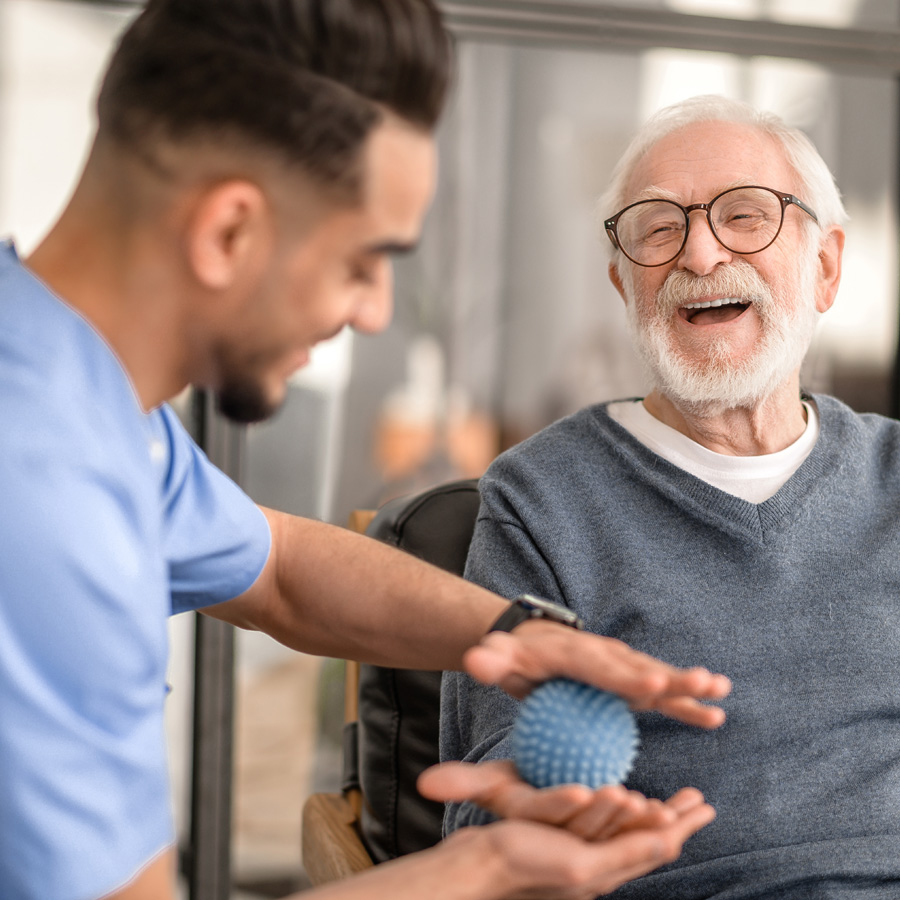an occupational therapist works with a senior man on dexterity