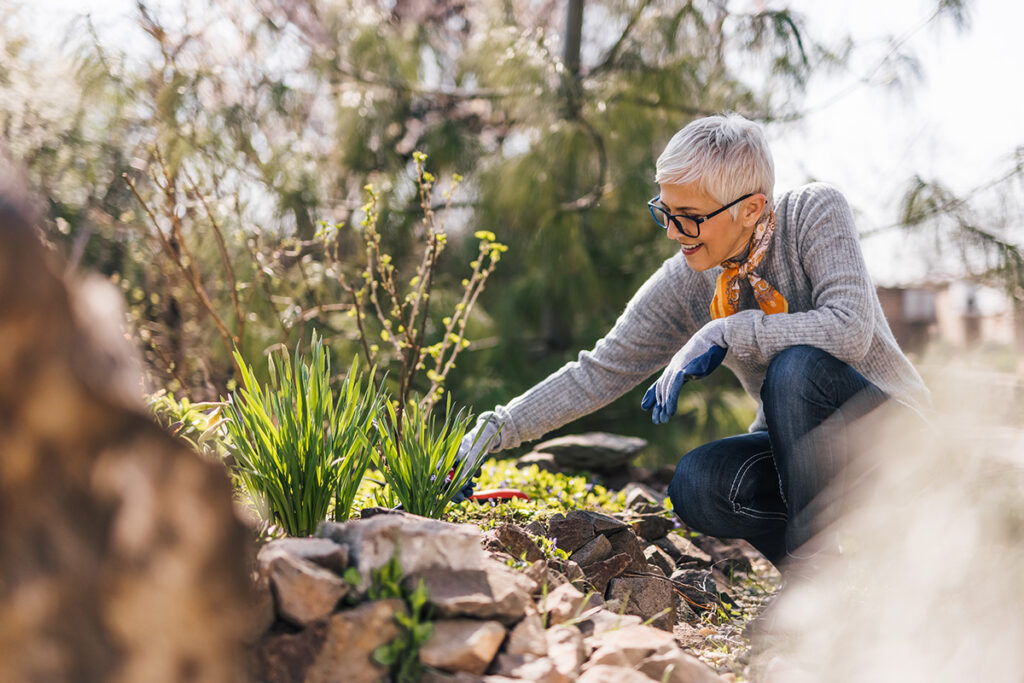 a senior woman tends to her garden