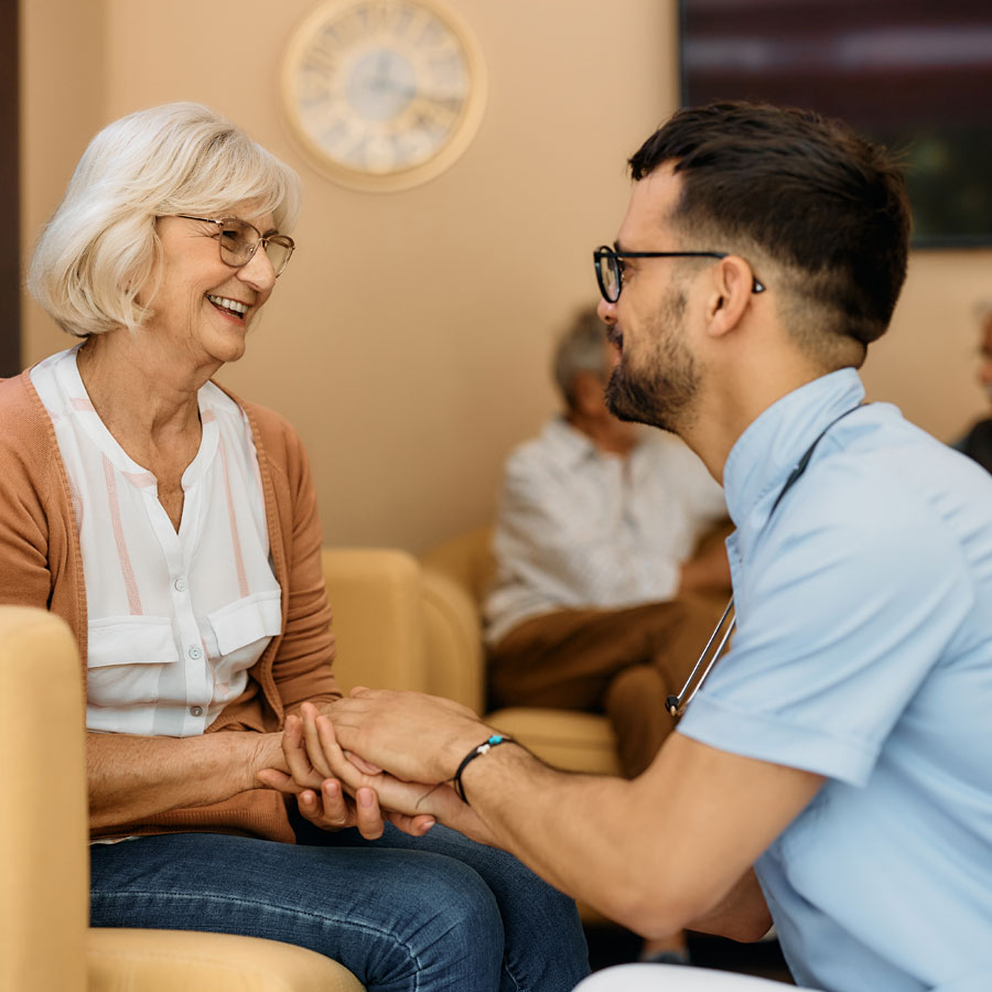 a nurse checks in with a senior woman in assisted living