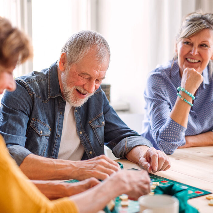 senior friends get together for a game night in assisted living