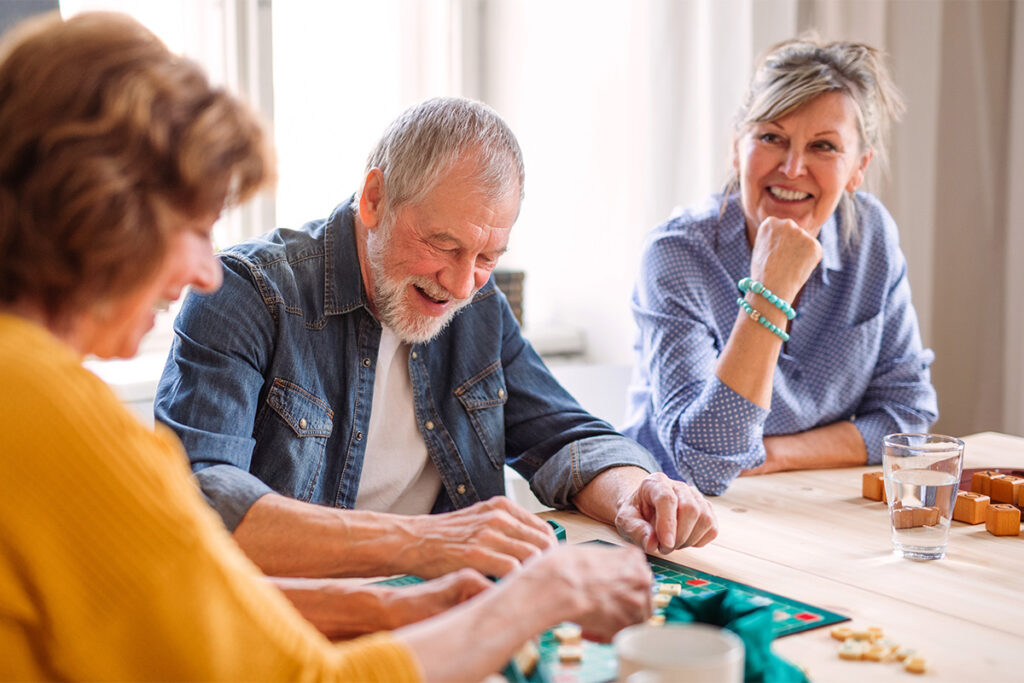 senior friends get together for a game night in assisted living