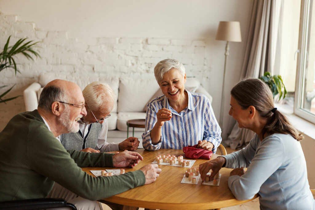 senior friends get together for a game night in assisted living