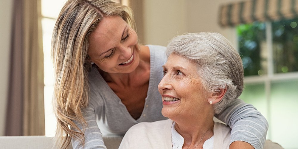a woman visits her aging mother in her memory care program