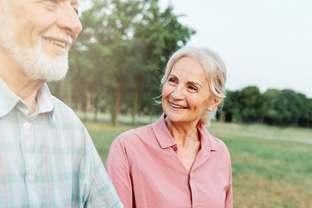 Elderly woman looking happily at elderly man