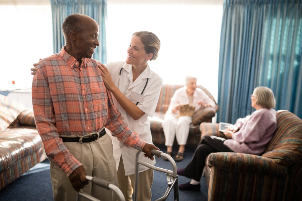medical professional helps older adult male with is walker another experience of life in assisted living