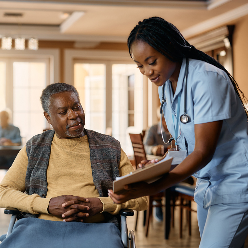 Healthcare worker reading paper to senior